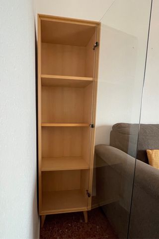 Vitrina en madera clara y puerta de cristal.