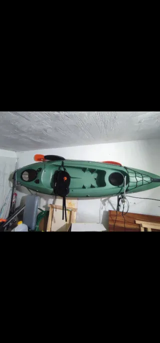 Kayak verde con remo y mochila