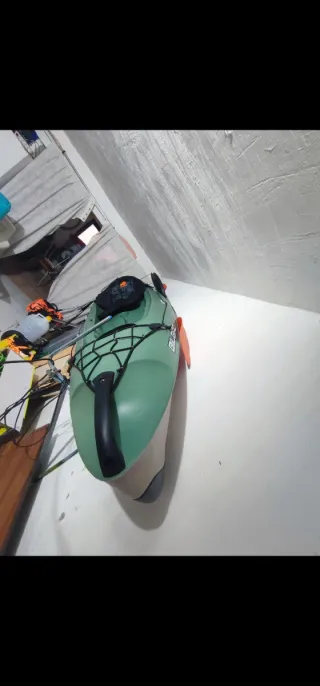 Kayak verde con remo y mochila