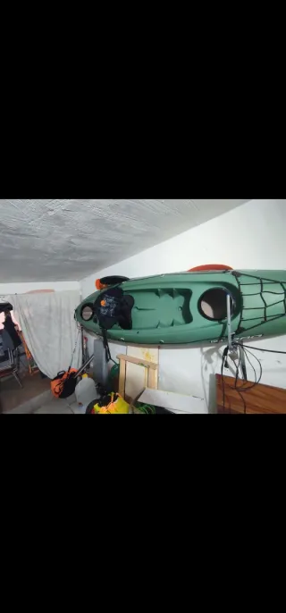 Kayak verde con remo y mochila