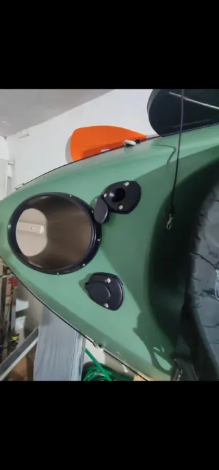 Kayak verde con remo y mochila