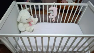Cuna de bebé blanca con osito y estrellas