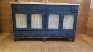 Mueble de baño azul con lavabos y grifos