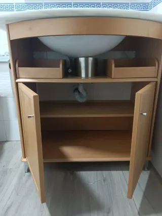 Mueble de baño con espejo, lavabo y grifo.