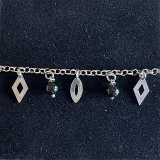 Bracciale con perle nere e ciondoli argentati