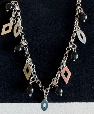 Bracciale con perle nere e ciondoli argentati