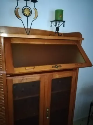 Mueble de madera con persiana y vitrina