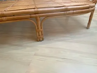 Banco de mimbre con cojín blanco