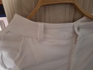 Pantalones blancos con cinturón dorado