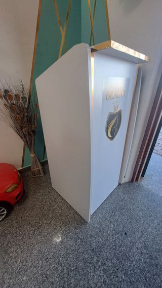 Mostrador de recepción blanco con detalles dorados