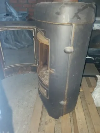 Estufa de leña negra con puerta de cristal