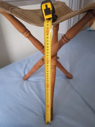 Silla de caza trípode de madera tratada y piel.