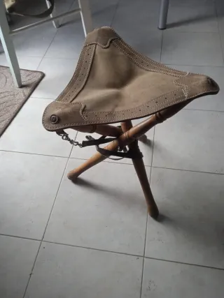 Silla de caza trípode de madera tratada y piel.