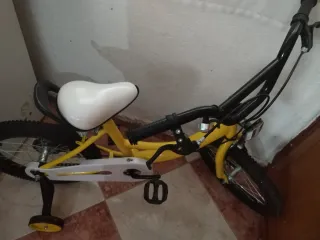 Bicicleta amarilla infantil con ruedines
