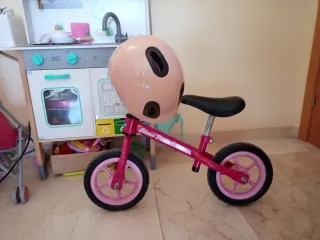 Bicicleta infantil rosa con casco y timbre