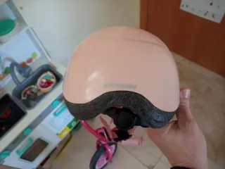 Bicicleta infantil rosa con casco y timbre