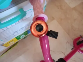 Bicicleta infantil rosa con casco y timbre