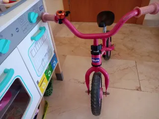 Bicicleta infantil rosa con casco y timbre