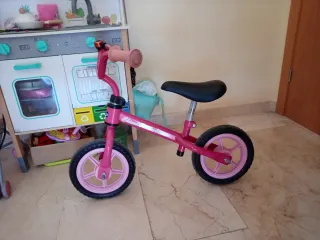 Bicicleta infantil rosa con casco y timbre