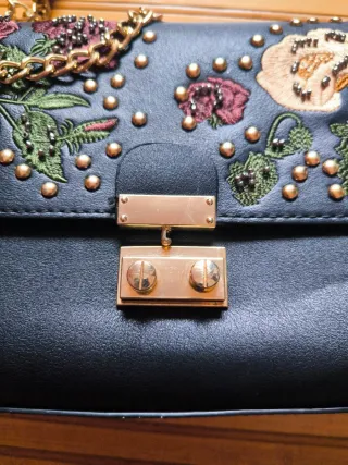 Bolso negro con cadena dorada y flores