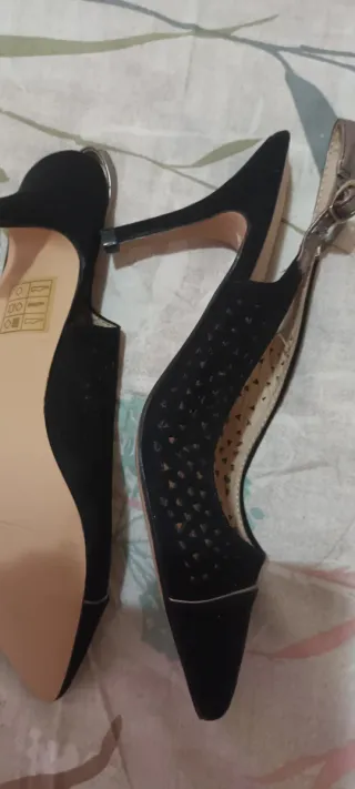 Zapatos negros destalonados con detalles dorados