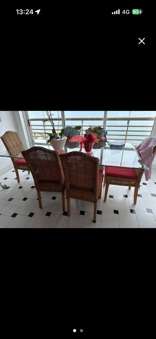 Mesa de comedor de cristal y sillas de mimbre