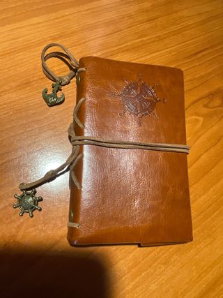 Libreta de cuero con brújula y ancla.