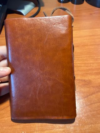 Libreta de cuero con brújula y ancla.