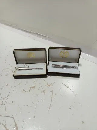 Dos Pasadores de corbata de metal plateado