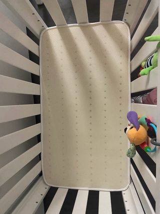 Cuna de madera con colchón.