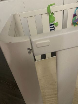 Cuna de madera con colchón.