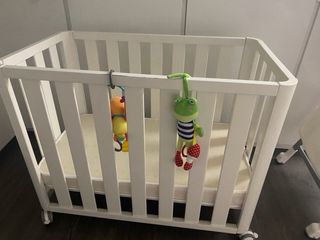 Cuna de madera con colchón.