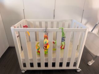 Cuna de madera con colchón.