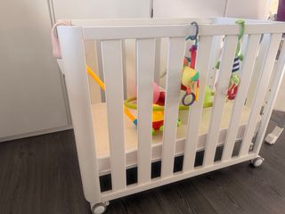 Cuna de madera con colchón.