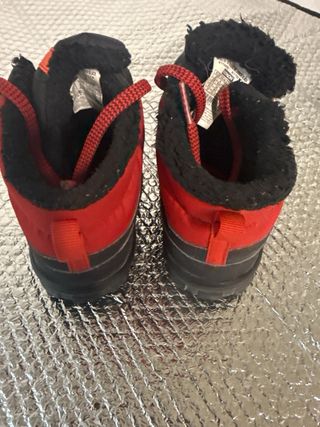 Botas de montaña Quechua negras y rojas.