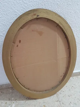 Espejo ovalado con marco decorativo dorado