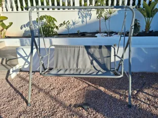 Columpio de jardín gris con toldo .