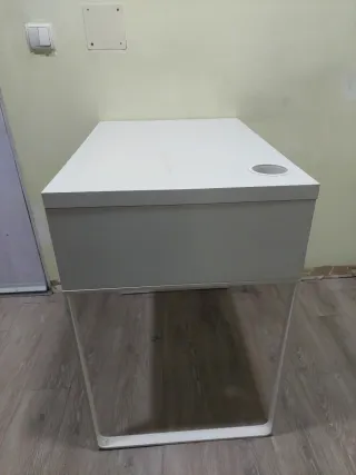 Escritorio blanco con cajón y silla.
