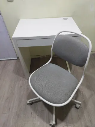 Escritorio blanco con cajón y silla.