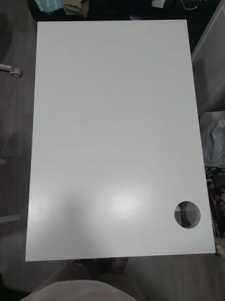 Escritorio blanco con cajón y silla.