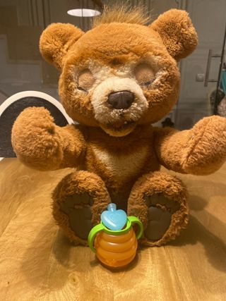 Oso de peluche curioso con biberón