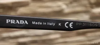 Occhiali Prada neri con dettagli rossi