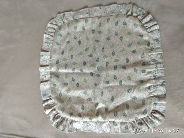 Funda cojín beige y verde con volante.