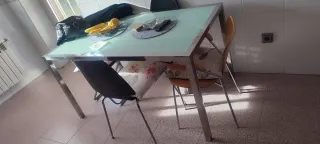 Mesa de comedor cristal y metal y dos sillas negra