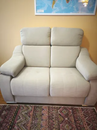 Sofá de tela beige de dos plazas. Está como nuevo