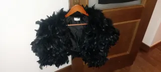 Vestido de fiesta negro con plumas y estola.