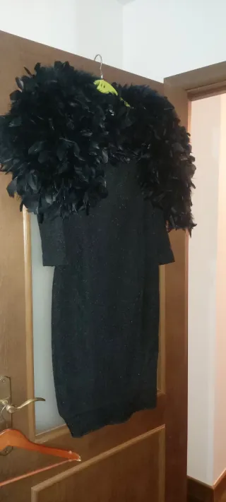 Vestido de fiesta negro con plumas y estola.