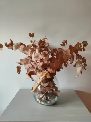 Jarrón de cristal con piedras y ramas secas