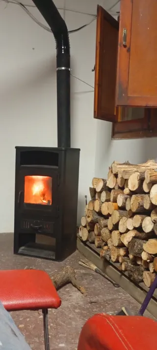 Estufa de leña negra con puerta de cristal