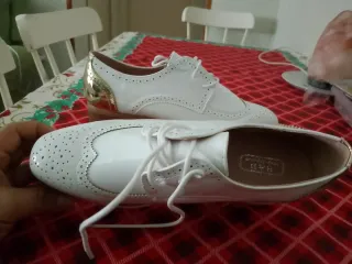 Zapatos blancos con detalle dorado